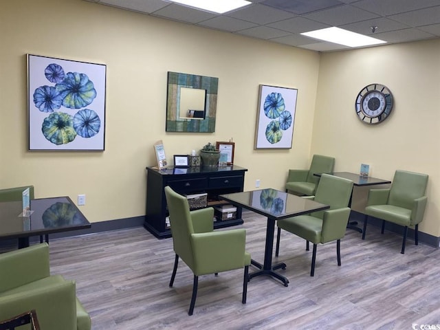 office area featuring a drop ceiling, light wood-style flooring, and baseboards