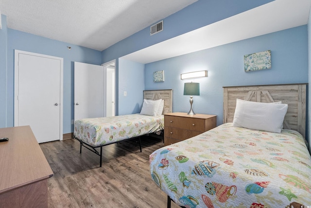 bedroom with hardwood / wood-style floors and a textured ceiling