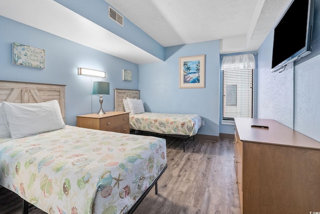 bedroom with light hardwood / wood-style floors and a textured ceiling