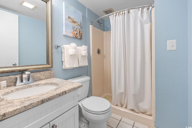 bathroom with tile patterned floors, vanity, toilet, and walk in shower