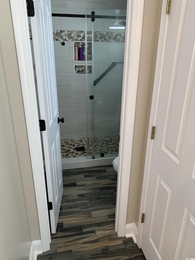 bathroom featuring hardwood / wood-style floors, toilet, and walk in shower