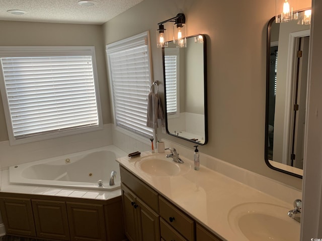 bathroom with vanity, a textured ceiling, and a bathtub