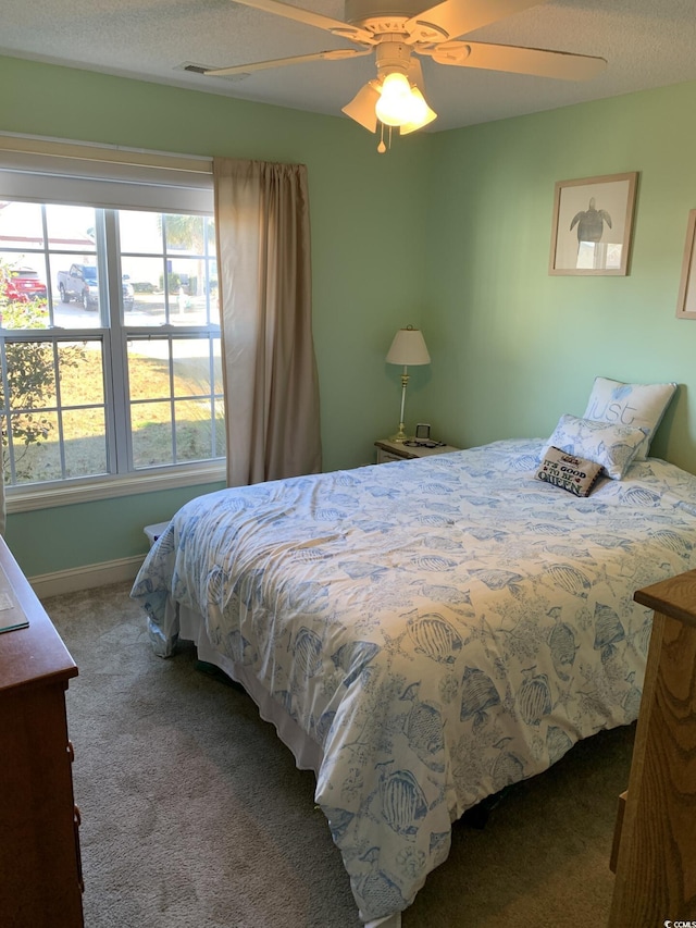 carpeted bedroom with multiple windows and ceiling fan