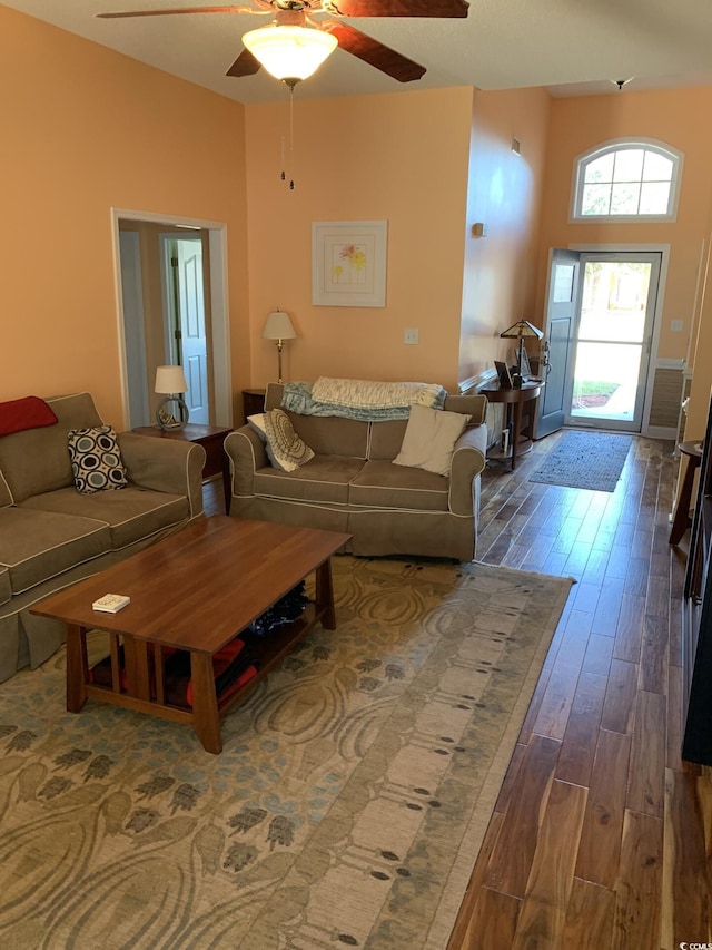 living room featuring ceiling fan and dark wood-type flooring