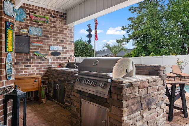 view of patio with area for grilling, exterior kitchen, and sink