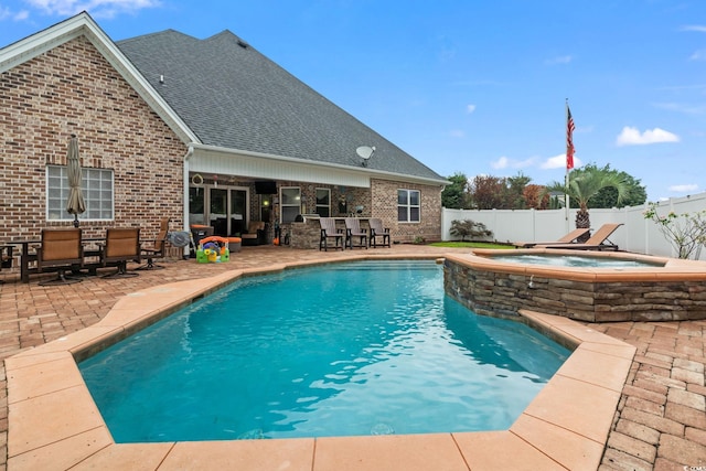 view of swimming pool with exterior bar, a patio, and an in ground hot tub