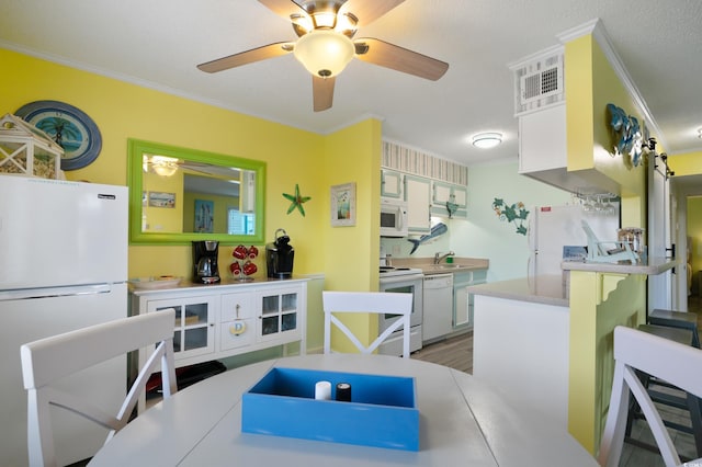 kitchen with sink, white cabinetry, white appliances, a breakfast bar, and crown molding