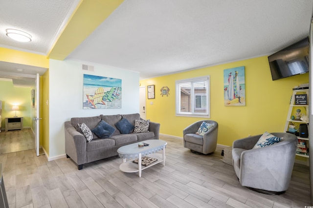 living room with a textured ceiling, light wood-type flooring, and crown molding