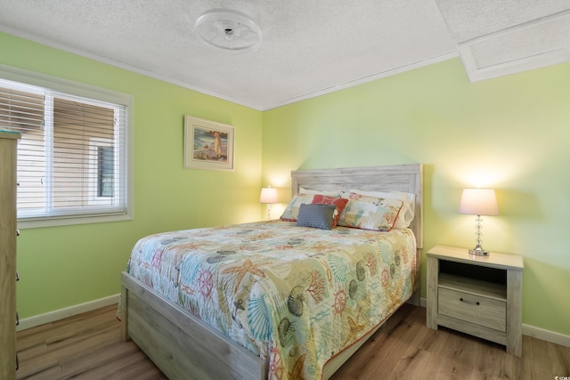 bedroom with a textured ceiling and wood-type flooring