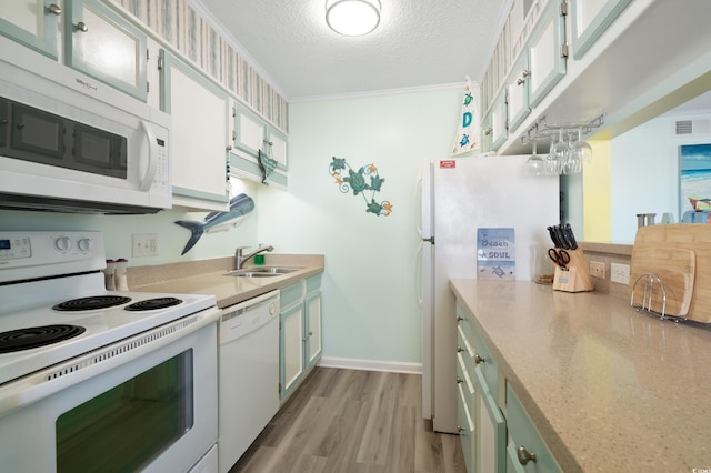 kitchen featuring sink, white cabinets, a textured ceiling, white appliances, and ornamental molding