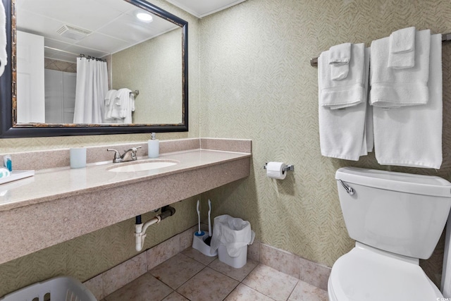 bathroom with crown molding, sink, tile patterned flooring, and toilet