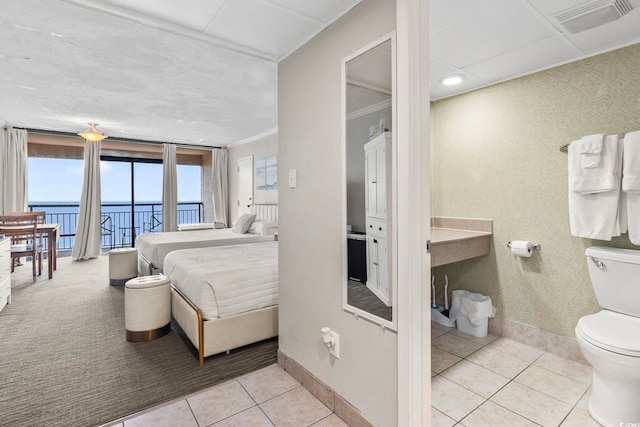 tiled bedroom with a water view and crown molding