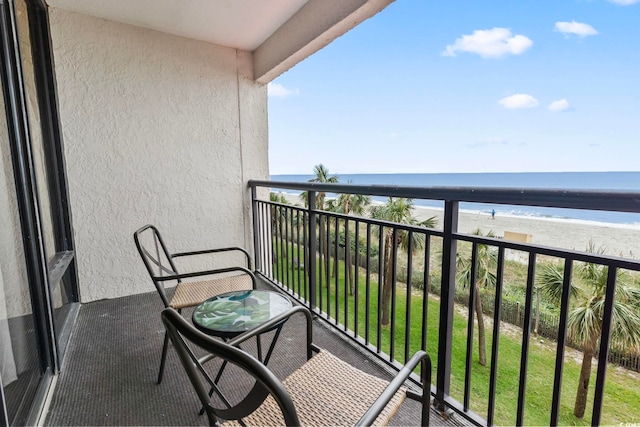 balcony with a water view and a view of the beach