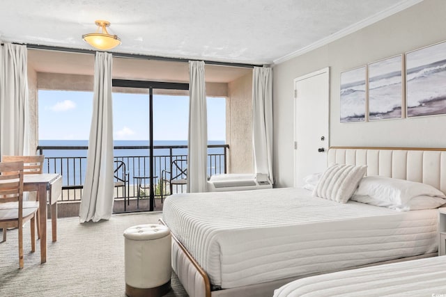 bedroom with access to exterior, a textured ceiling, a water view, carpet, and ornamental molding