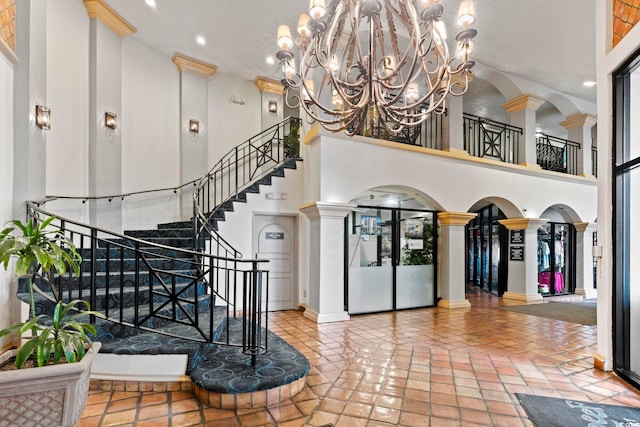 interior space with decorative columns, french doors, a high ceiling, and a notable chandelier