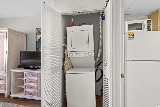 501 S Ocean Blvd Unit 708, North Myrtle Beach, SC 29582 - washroom featuring stacked washing machine and dryer and wood finished floors