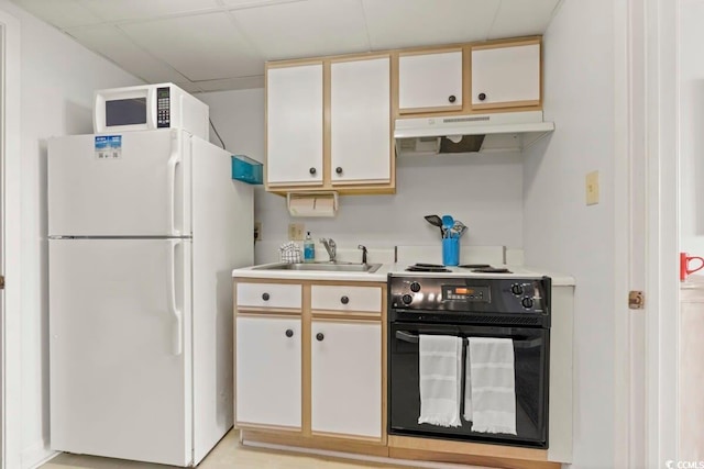 kitchen with a drop ceiling, sink, white appliances, and white cabinets