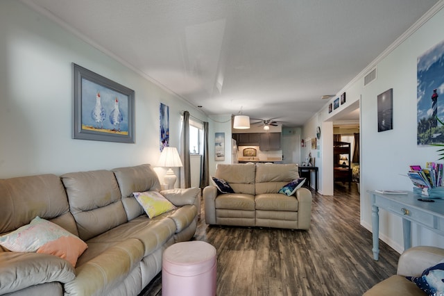 living room featuring a textured ceiling, dark wood-type flooring, ceiling fan, and crown molding