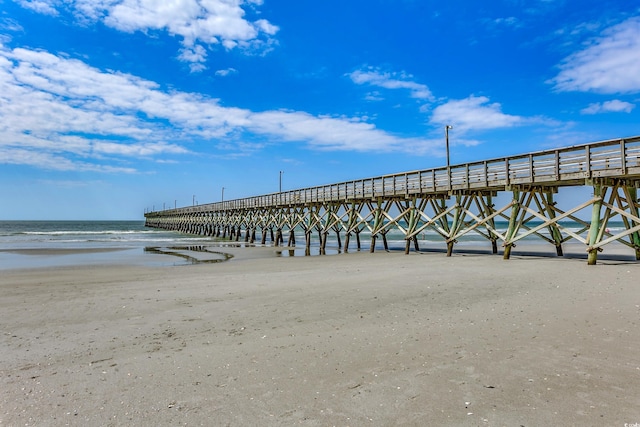 dock area with a water view and a view of the beach