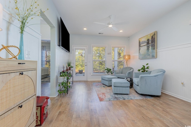 living area featuring hardwood / wood-style floors and ceiling fan