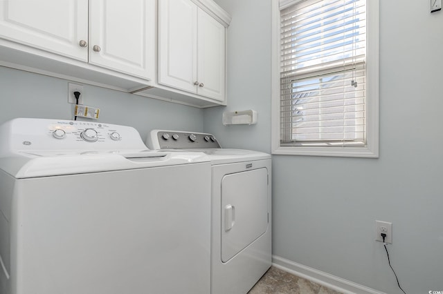 laundry room featuring washing machine and clothes dryer and cabinets