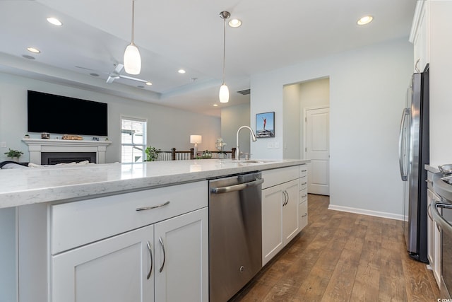 kitchen with white cabinets, appliances with stainless steel finishes, pendant lighting, and sink