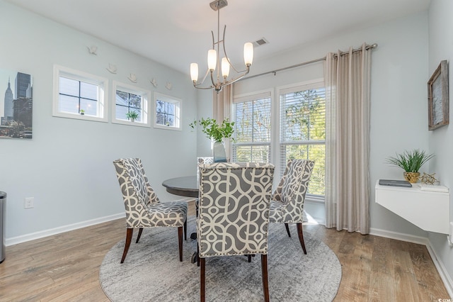 dining room featuring wood-type flooring and an inviting chandelier