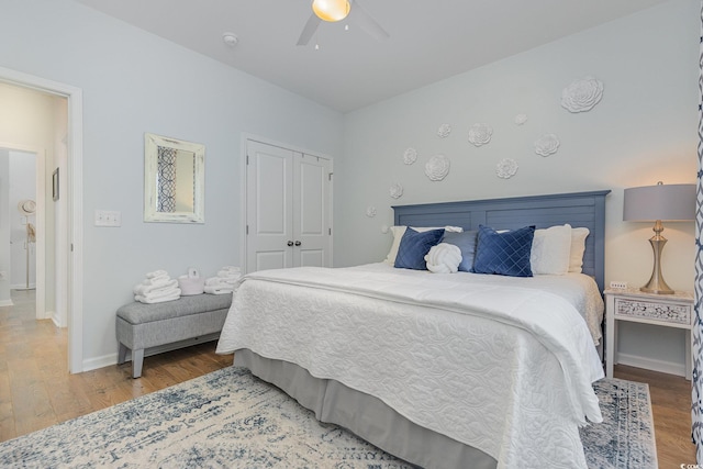 bedroom with hardwood / wood-style floors, ceiling fan, and a closet