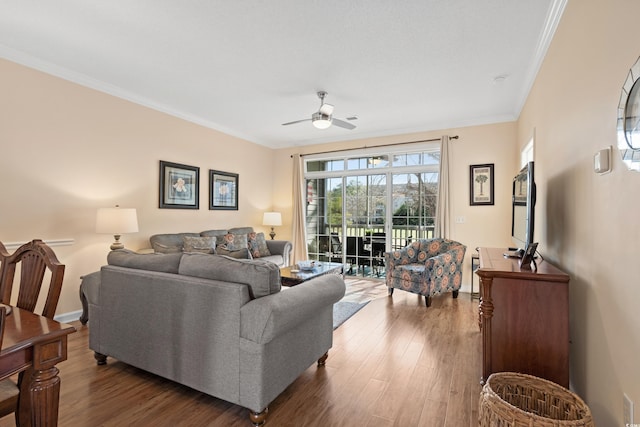 living room with crown molding, ceiling fan, and dark hardwood / wood-style floors