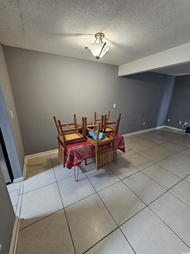 tiled dining area featuring a textured ceiling