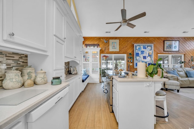 kitchen with white cabinetry, stainless steel electric range oven, and wood walls