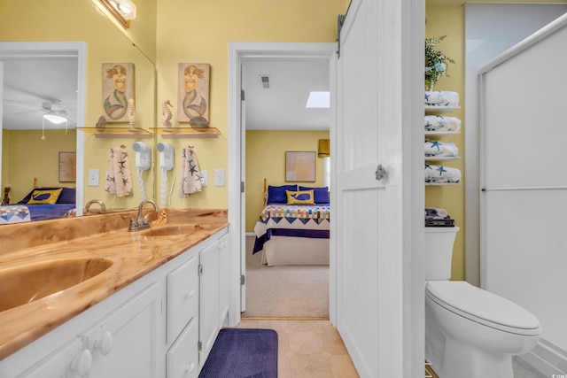 bathroom featuring vanity, toilet, and ceiling fan