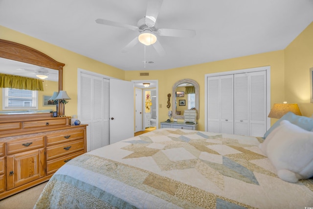 bedroom featuring ceiling fan and two closets