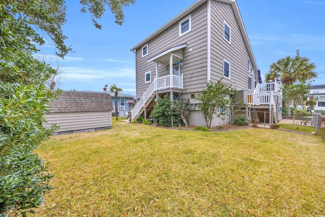 rear view of property with a yard and a storage shed