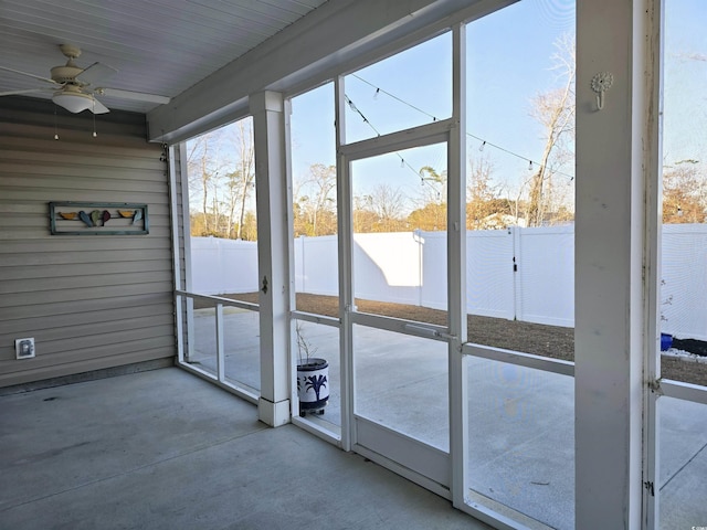 unfurnished sunroom with ceiling fan