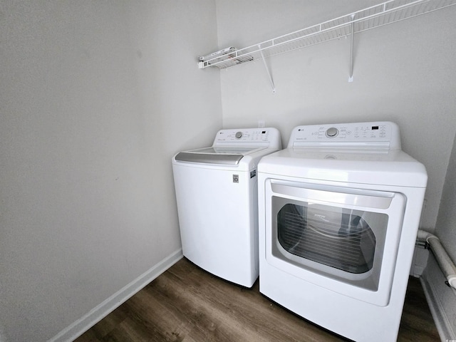 laundry area with dark hardwood / wood-style floors and washing machine and clothes dryer