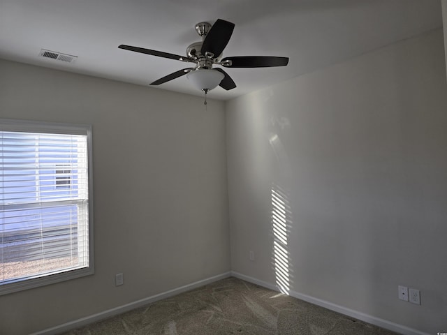 unfurnished room with a wealth of natural light, carpet floors, and ceiling fan