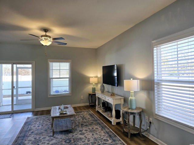 living room featuring ceiling fan and dark hardwood / wood-style flooring