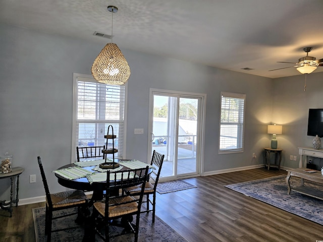 dining space with a wealth of natural light, ceiling fan, and dark wood-type flooring