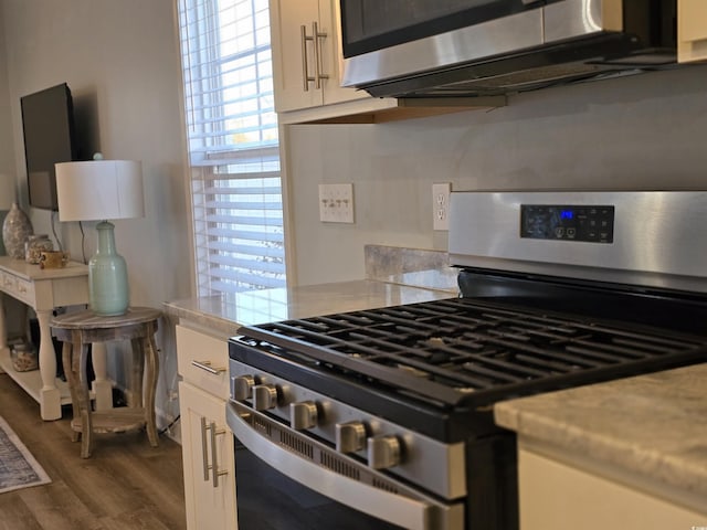 kitchen featuring white cabinets, gas range, and dark hardwood / wood-style flooring