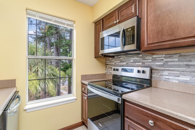 kitchen with stainless steel appliances, decorative backsplash, and light tile patterned floors