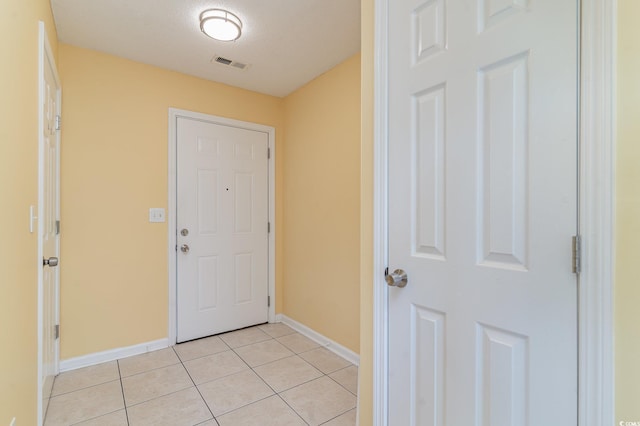 entryway with a textured ceiling and light tile patterned floors