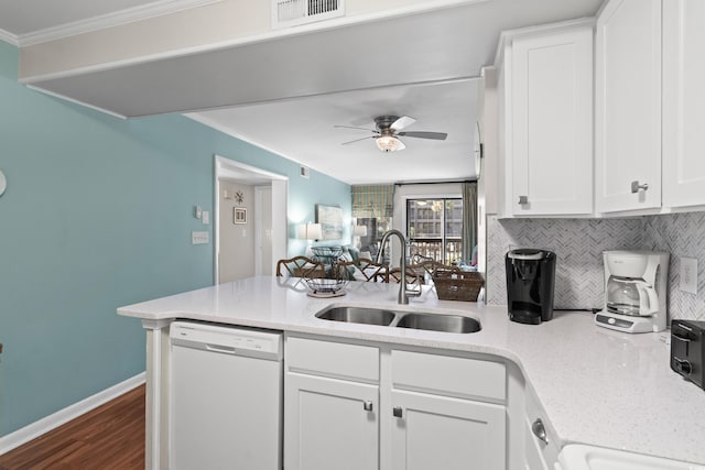 kitchen featuring white dishwasher, decorative backsplash, white cabinets, and sink