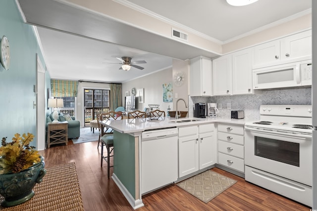 kitchen with kitchen peninsula, white appliances, crown molding, sink, and white cabinets