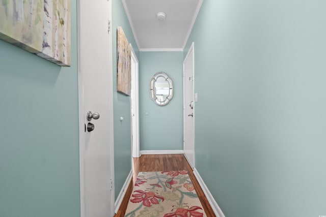 corridor with hardwood / wood-style floors and ornamental molding