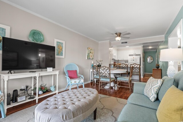 living room featuring hardwood / wood-style flooring, ceiling fan, and crown molding