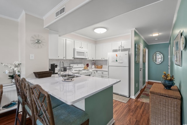 kitchen featuring kitchen peninsula, white appliances, white cabinetry, and sink