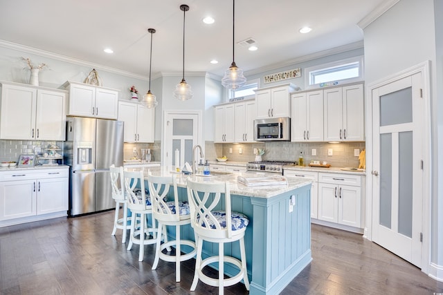 kitchen featuring white cabinets, stainless steel appliances, and an island with sink