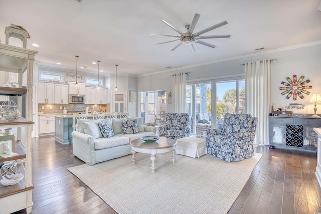 living room with ceiling fan, dark hardwood / wood-style flooring, and crown molding