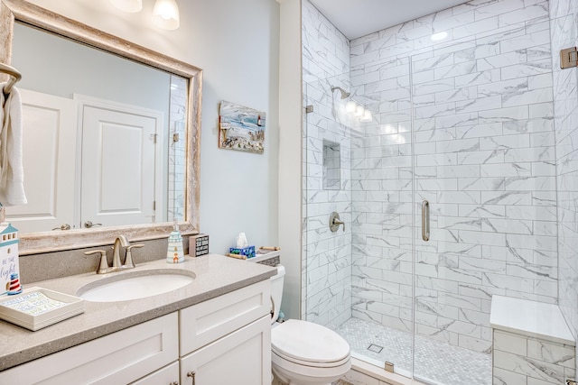 bathroom with vanity, toilet, and a shower with shower door